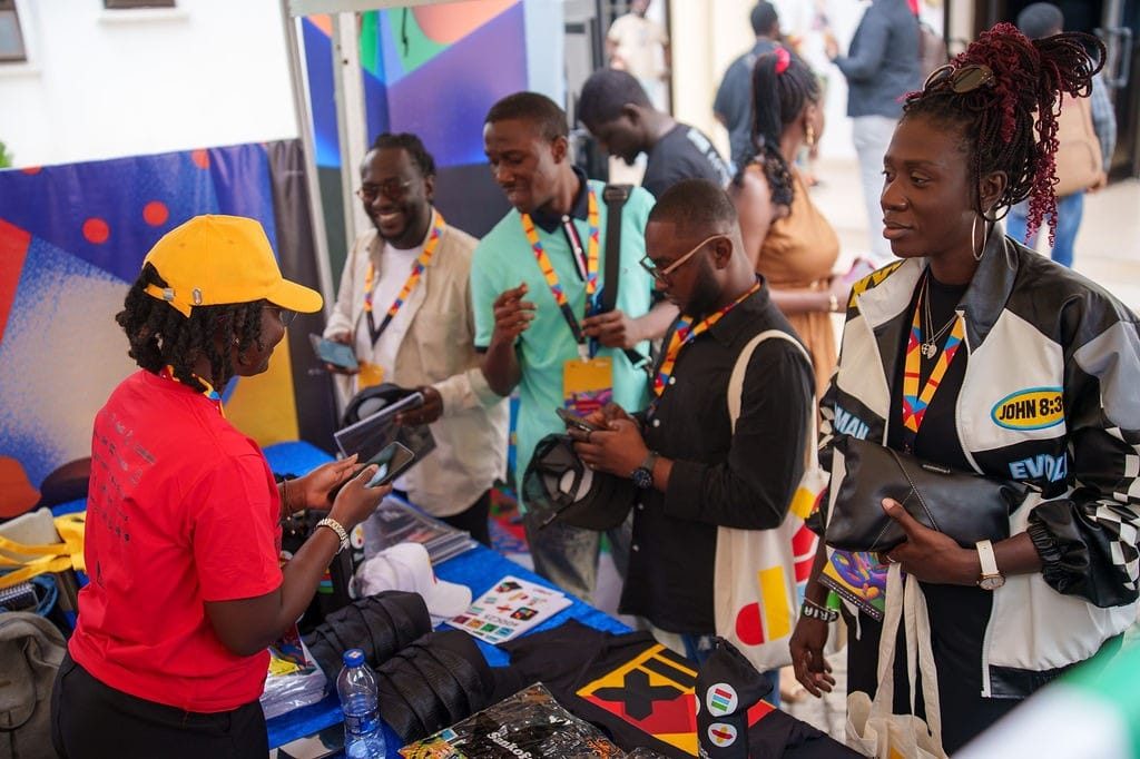 dEX Design Conference 2025 — attendees browsing an exhibitor’s table of design merchandise