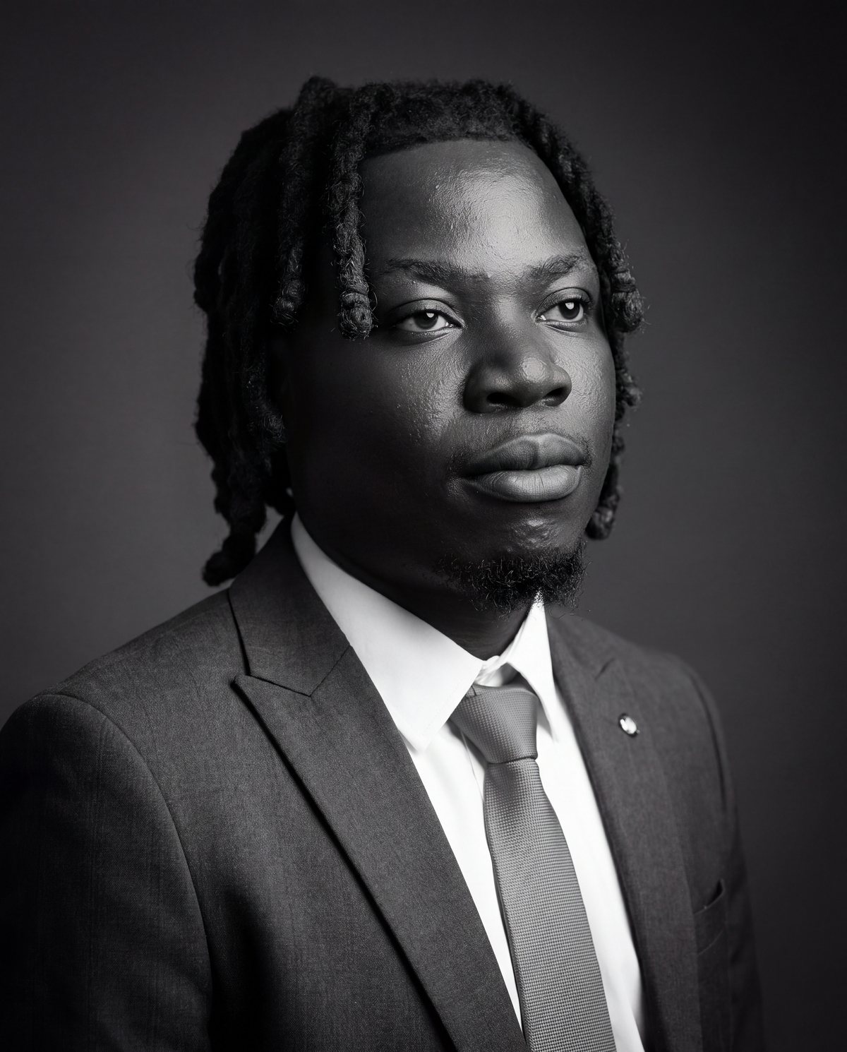 Black-and-white portrait of Nicholas Adusei Agblevor in a suit and tie